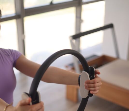 MZ세대부터 중장년층까지… 필라테스로 활기찬 일상 가꾸기 a woman sitting on the floor holding a steering wheel